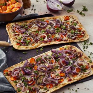 Flammkuchen met rode ui, wortel, tijm, spekjes en een wortelsalade