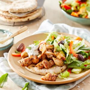Roerbak gyros van polderhoen met komkommer-paprikasalade, pitabroodjes & yoghurt-muntdressing