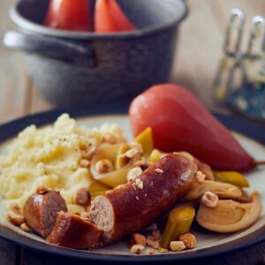 Biologische Neijmeijer saucijsjes met prei, hazelnoten, snel gestoofde peer en aardappelpuree